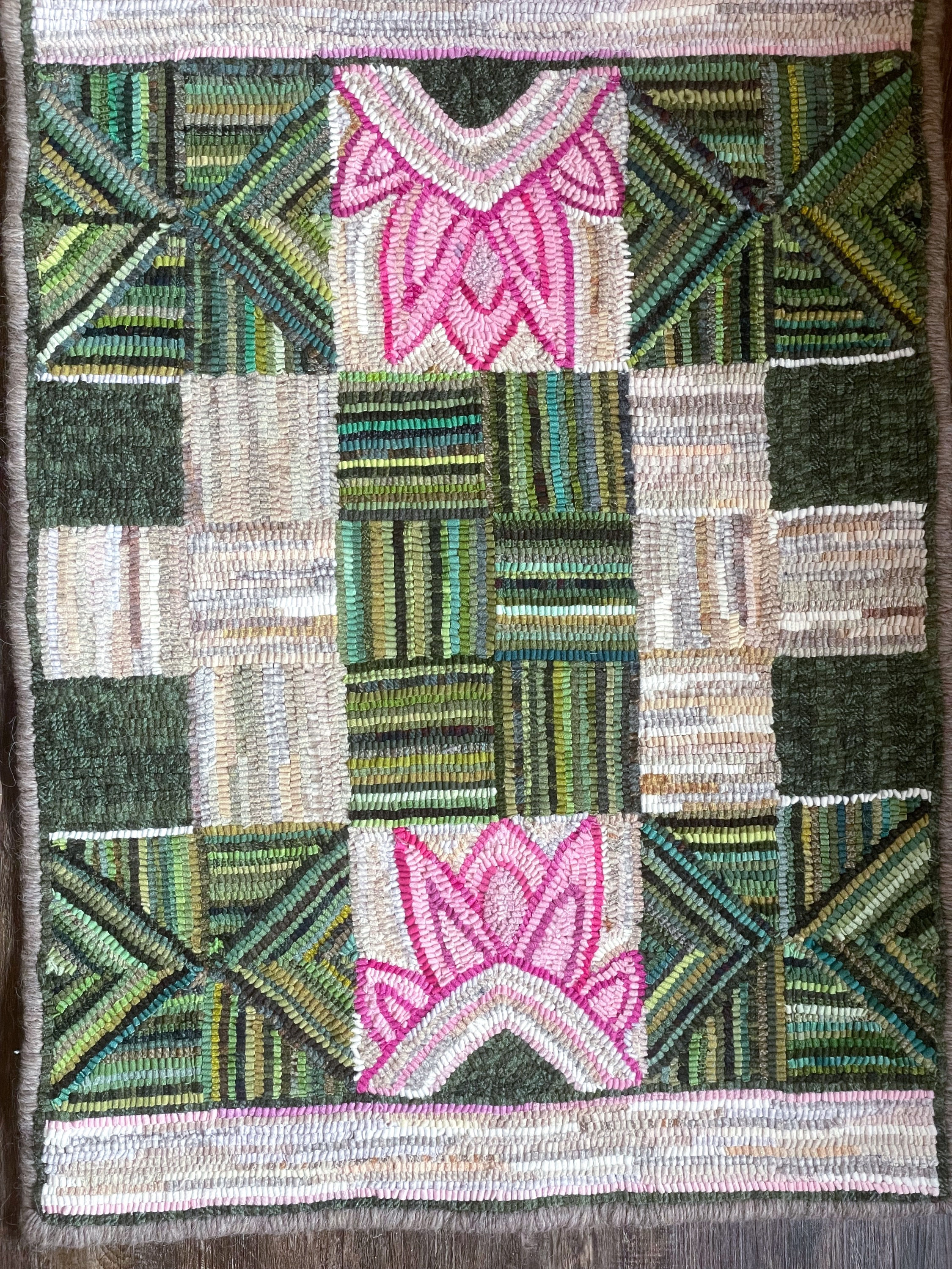 geometric hooked rug in greens and neutrals