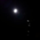 dark room with a light in the corner, shining on a microphone and a camera is set up in th