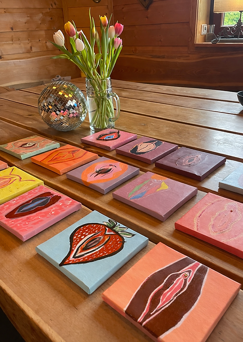 Table with 10 abstract paintings created in a Berlin workshop, decorated with a disco ball and flowers