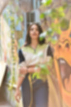 Outdoor Photoshooting auf der Seitengasse hinter Planzen und Graffity im Hintergrund