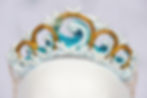 Close-up of a wave crown with gold accents and light blue details.