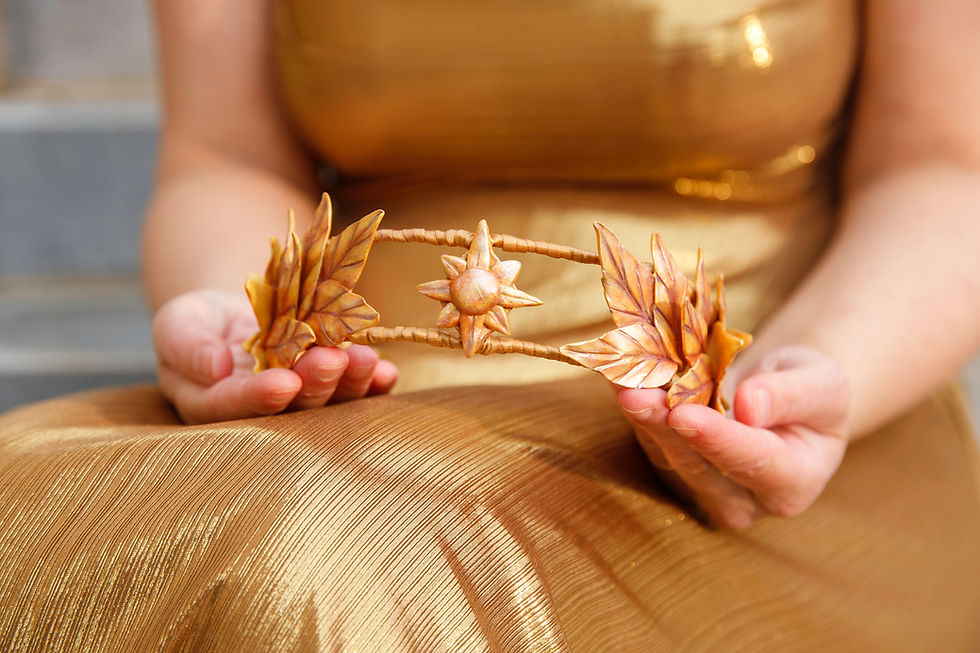 Thumbnail: Crown with gold colored leaves and sun in the middle held in hands