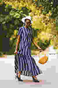 Woman in stripe dress walking with a basket bag in her hand