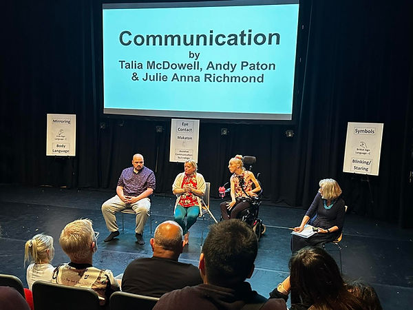 Question and answer panel is taking place on the stage in relation to the piece which is called Communication and the title is projected on the large screen behind.