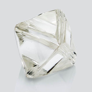 Weißer Rohdiamant aus Tierasche oder Haaren vor hellem Hintergrund