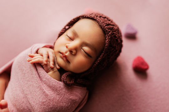 Closeup of Newborn Baby in hand knitted bonnet