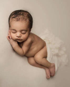 Full body newborn portrait with soft shadows and warm tones
