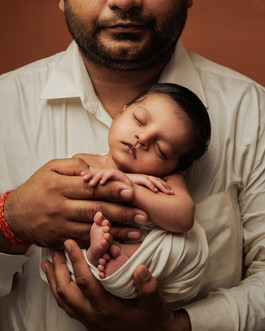 Classic newborn portrait with dad gently holding baby