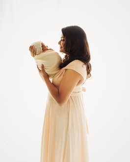 Candid shot of mom admiring newborn in a maternity-meets-newborn shoot