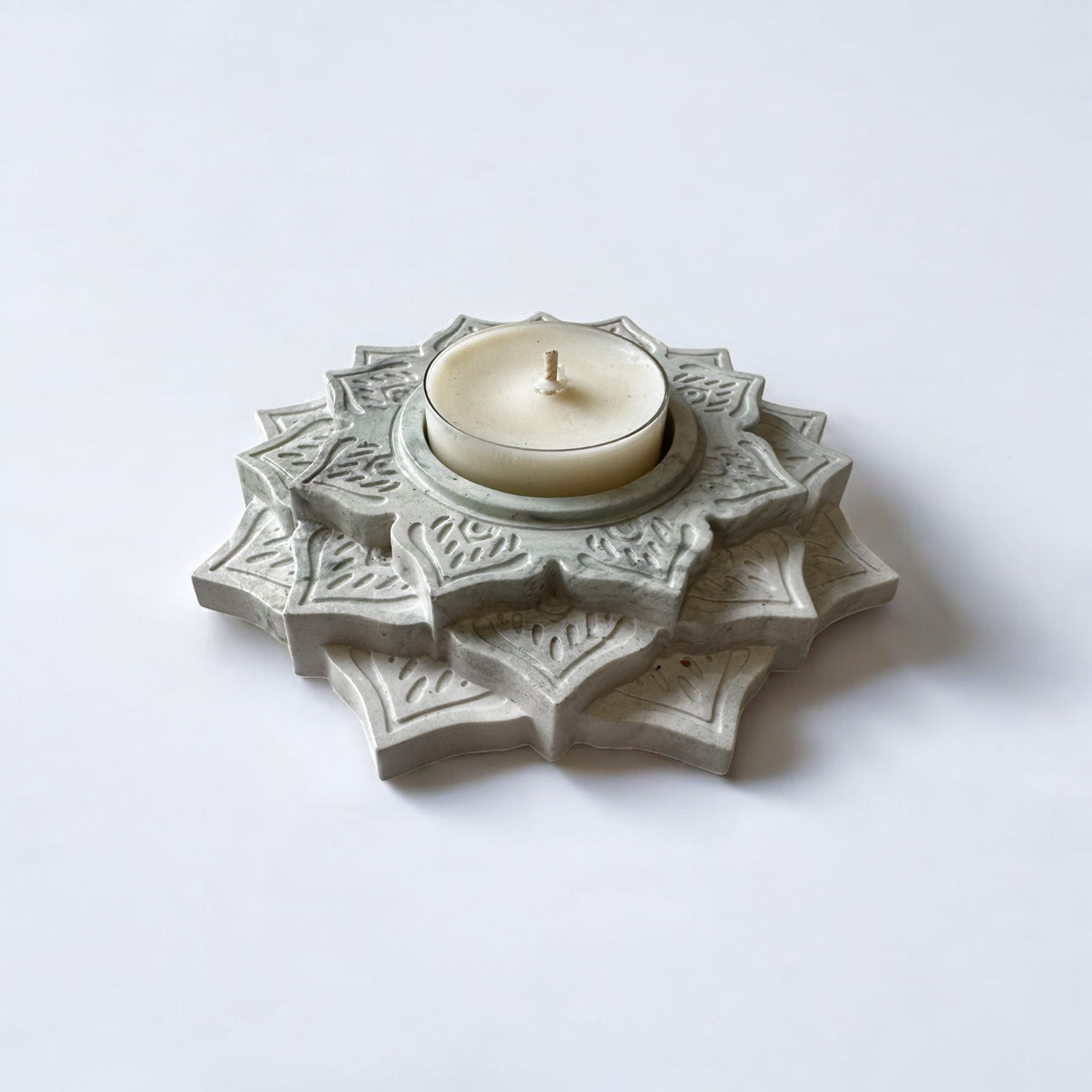 Teelichthalter mit einem Teelicht auf hellem Untergrund