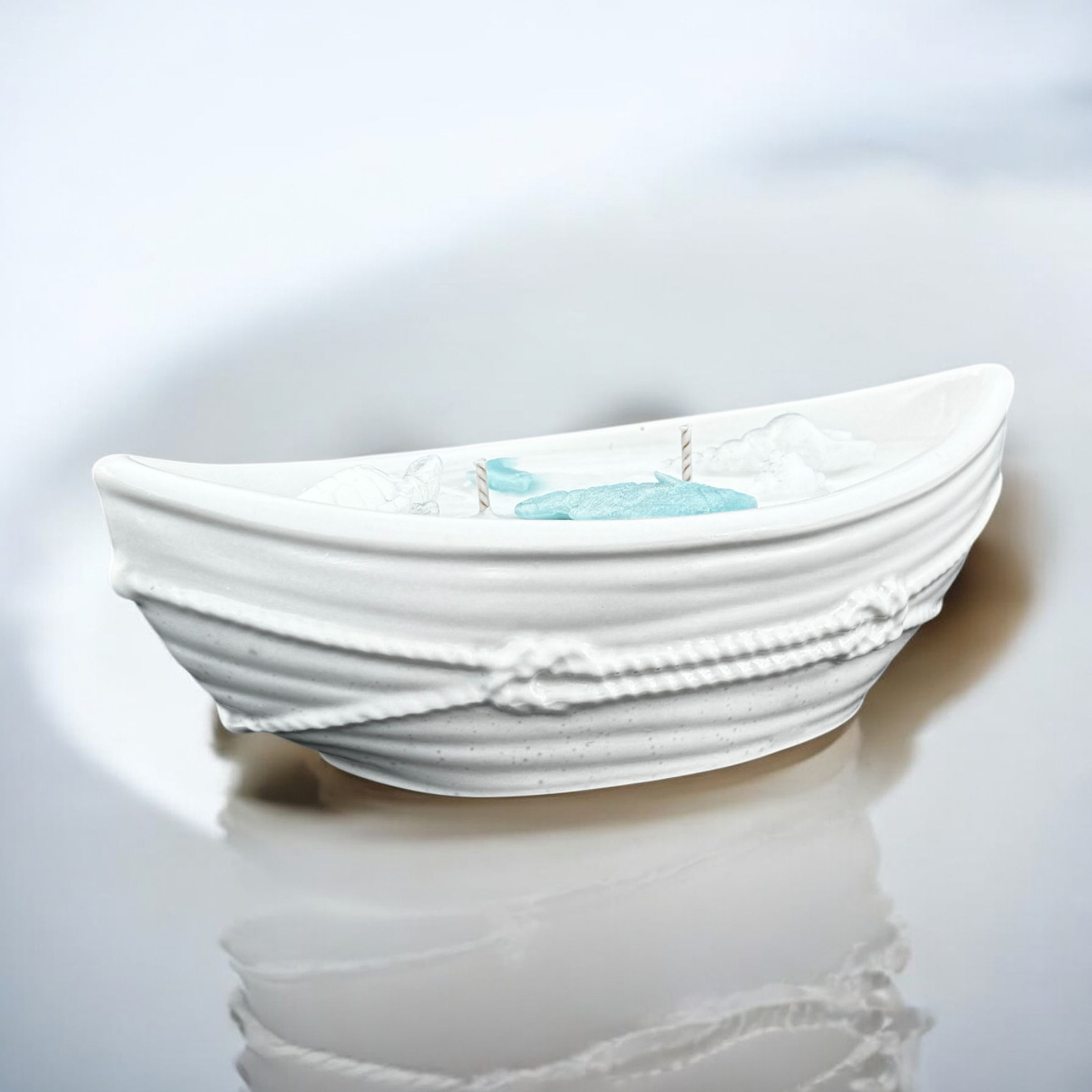 Weiße Kerze im Gefäß in Form eines Bootes