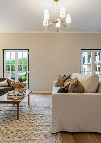 Open-plan living room in Beloura’s Viela da Eira apartment with stylish furnishings, statement lighting, and inviting ambiance.