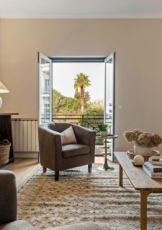 Open-plan living room in Beloura’s Viela da Eira apartment with stylish furnishings, statement lighting, and inviting ambiance