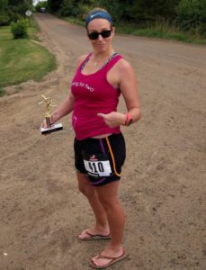 Sasha holding a trophy and pointing at her baby bump