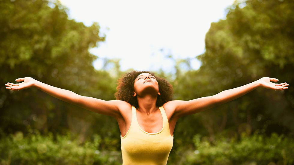 Eine Frau streckt sich freudig zur Sonne hin