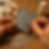 Hands painting a miniature gray metal roof with a brush. Palette with paint and a Satin Varnish bottle are in the background.