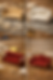 Four miniature sofas, from cardboard to ornate red velvet, are displayed on a craft table with tools and materials.