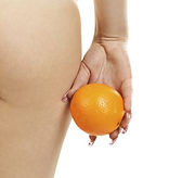 Oberschenkel einer dünnen Frau die eine Orange in der Hand hält