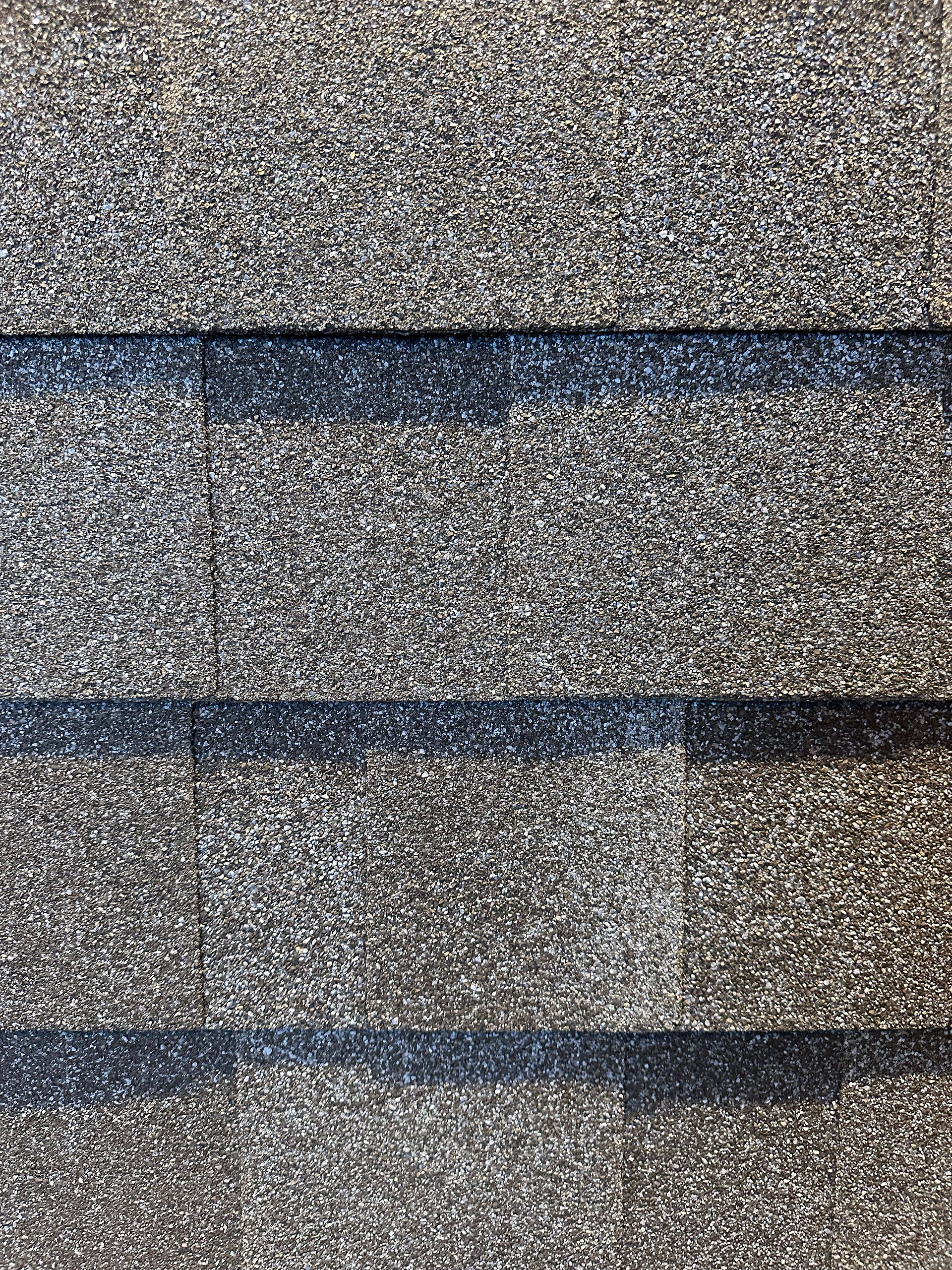 Dark brown asphalt shingles with rich earthy tones, providing a durable and traditional roofing solution for homes.