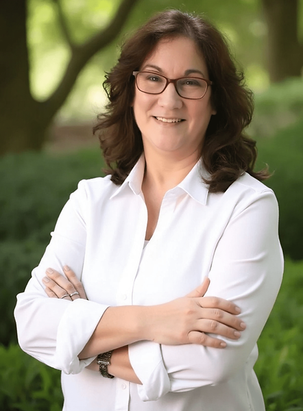 April Cox smiling with crossed arms.