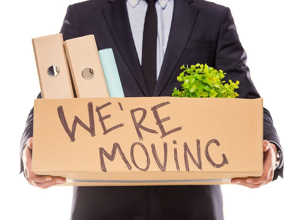 Person in suit holding a box labeled "WE'RE MOVING" with folders and a green plant inside. White background, suggesting relocation.