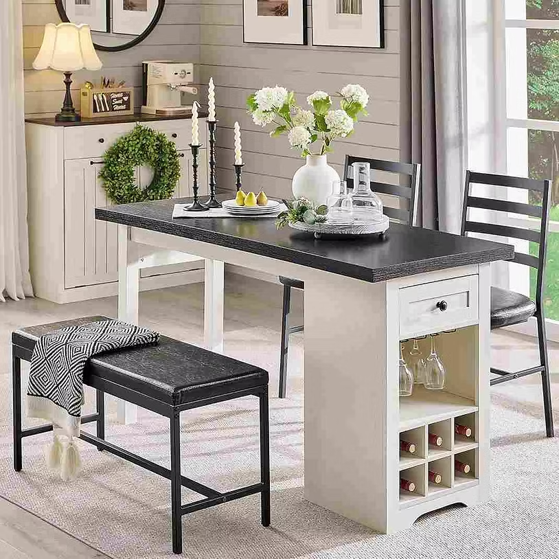 Modern dining room with black table, chairs, and bench. Vase with white flowers, candles, and wine storage; cozy, elegant ambiance.