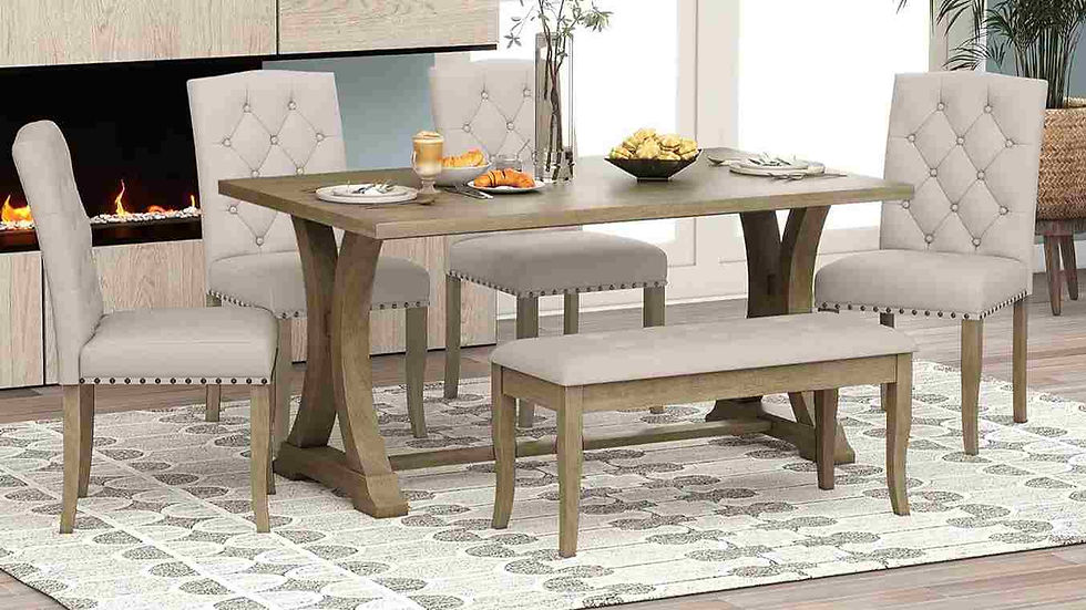 Dining set with beige chairs and a bench around a wooden table, against a fireplace. Plates and fruit on table, rug below, cozy mood.