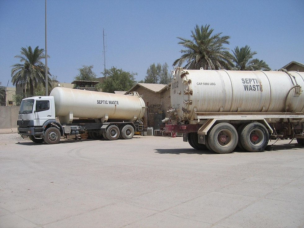 Two septic waste trucks are parked in a sunny area with palm trees and buildings in the background. Visible text reads "SEPTIC WASTE."