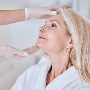 A mature woman getting a skin care consultation.