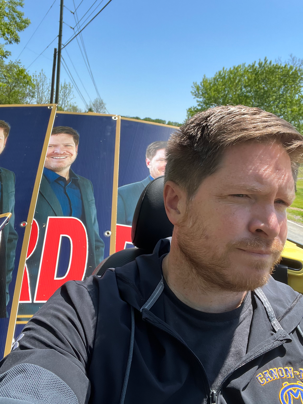 politician picks up and drivers around his yard signs