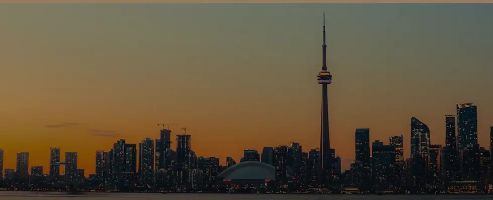 Toronto skyline at sunset with CN Tower and Rogers Centre in view.