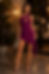 Woman in a purple one-shoulder dress at night