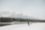 Bride and groom walking by Bow River at Riverside Park in Canmore
