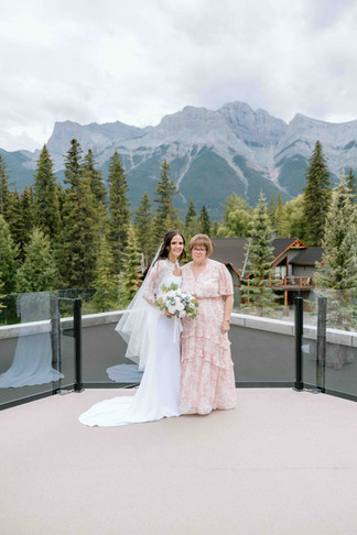 Bride posing with her mom for a photo