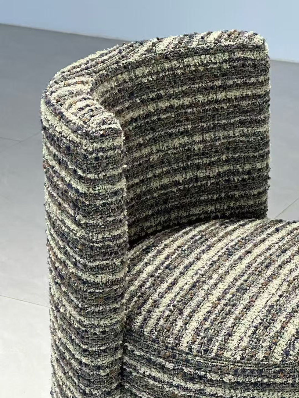 Close-up of textured upholstered chair with layered fabric detail.