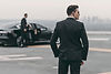 Executive protection professional guarding a black car