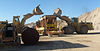 2 tracktors filling a machine with dirt