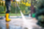 person-yellow-boots-pressure-washing-patio-surrounded-by-lush-garden-sunny-day_edited.jpg