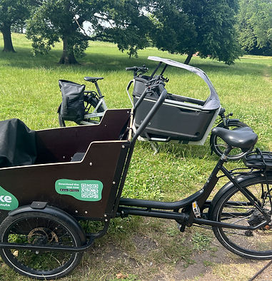 Two cargo bikes parked on the grass