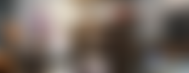 A nautical-themed exhibit inside the Poulsbo Maritime Museum featuring a large wooden sign reading "VERONA" above a red and white model boat. The display includes vintage fishing tools, buoys, ropes, and maritime artifacts hanging from rustic wooden panels. Nearby glass cases contain historical photographs, documents, and maritime instruments, while a large photo of boats in a marina hangs on the wall.