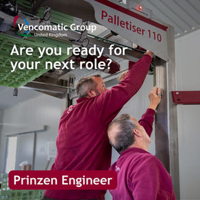 2 Male engineers in burgundy Prinzen jumpers working on a large metal machine that stacked trays of eggs for farms