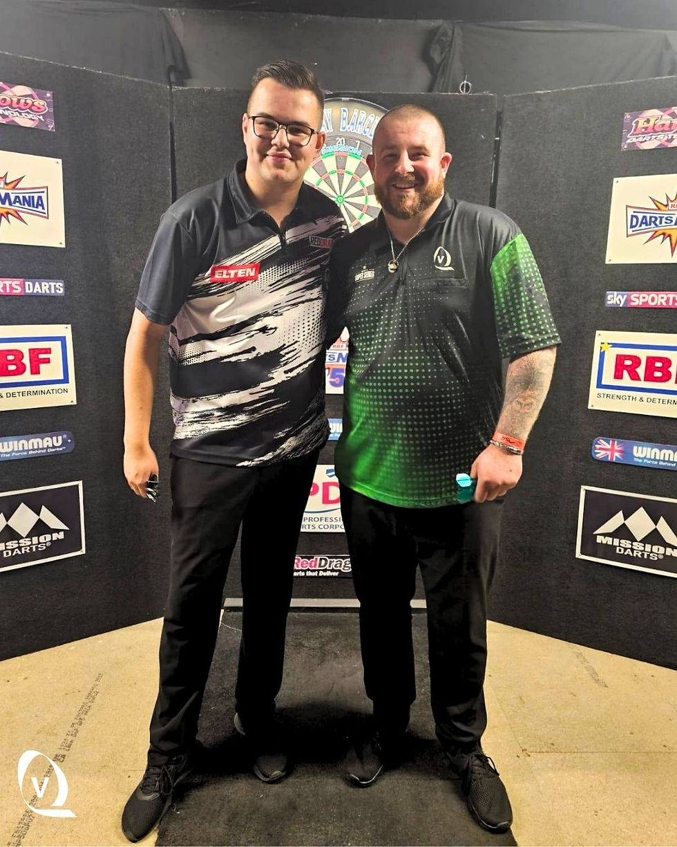 Adam Winspear and Jim Moore hold up Adam's sponsored Darts Shirt