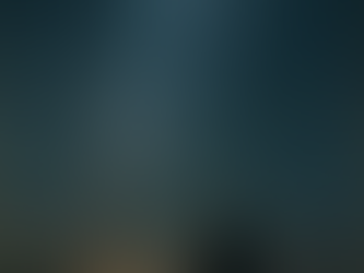 A lone figure stands beneath a vast, starlit sky, gazing upward as the Milky Way stretches across the twilight horizon.