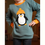 Miniaturbild: Kind trägt Pullover mit Pinguin-Applikation, weißer Bauch, schwarze Flügel, orangefarbene Wintermütze.