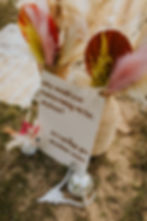 A sign with disco balls, antlers and flowers sitting on the ground.
