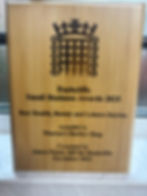 Eye-level view of a trophy on a wooden table with a blurred background of a celebration event