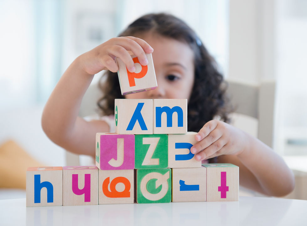 Girl stacking letter blocks for speech pathology rebates.