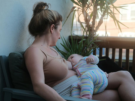 Mother breastfeeding baby in a calm outdoor setting