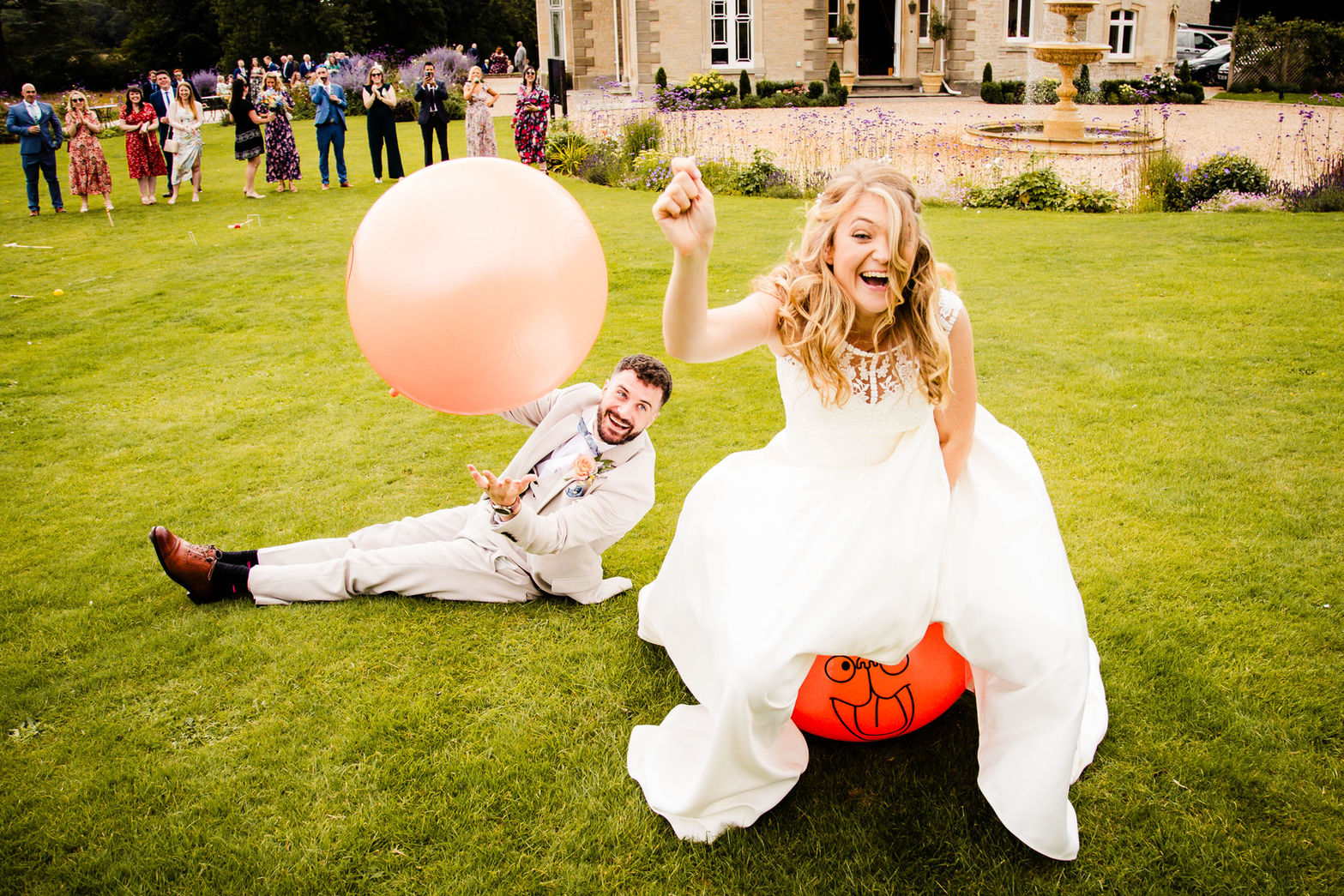 Fun photo of bride and groom on space hoppers at St Tewdrics House