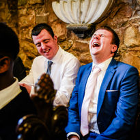 guests laugh during wedding ceremony at St Pierre in Chepstow